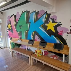 a wall with the J4K logo on it, in a graffiti style